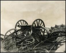 [Cannon in pile of old metal wheels]