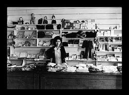 Woman standing behind store counter