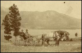 Joe Young and unidentified man in wagon with team above Columbia Lake