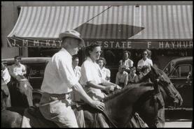 [Unidentified man and woman on horseback in parade]