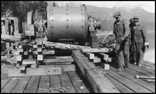 Unloading mining machinery from a barge at the Ewings Landing C.P.R. wharf
