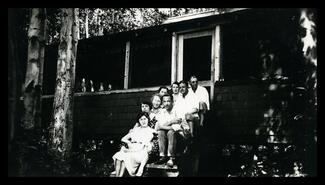 Group on the steps of a summer cabin, probably at Christina Lake