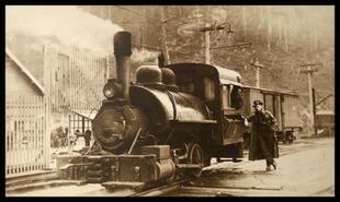 Man leaning on Davenport locomotive at Granby Mine