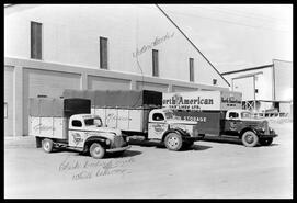 Three Vernon Storage Co. Ltd. trucks parked outside the storage company warehouse