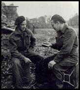 Canadian Regiment members Bill & Archie Allan checking a revolver from a recent battle