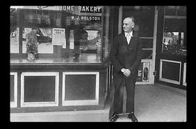 W.J. Rolston in front of Home Bakery on Barnard Avenue