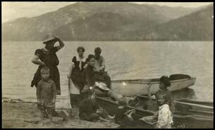 Group with two boats on shore at Christina Lake