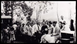 Group of adults and some children enjoying a community picnic overlooking Wood Lake near Petrie's Corner