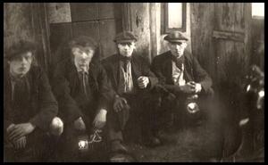 Four coal miners posing before shift