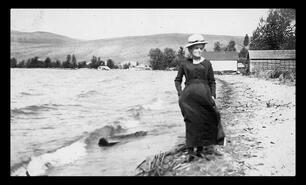 Unidentified woman on Kalamalka Lake waterfront on a windy day