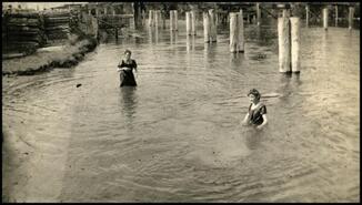 Two young women swimming in Columbia River above first bridge, Athalmer