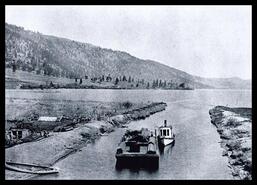 "Maud Allen" pushing a barge loaded with loads through the new canal at Oyama