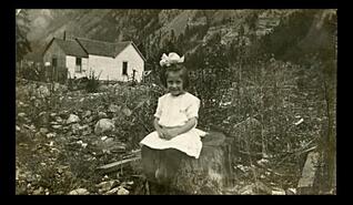 Young girl, possibly Emma Lois Boeing sitting on a stump