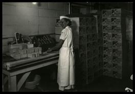 [Woman wrapping butter at N.O.C.A. facility]