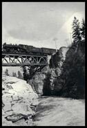 C.P.R. train crossing metal bridge spanning canyon at Cascade falls
