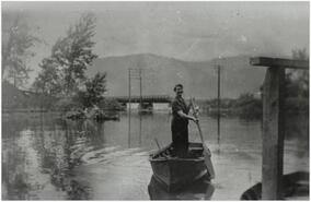 Olgi Norwood in rowboat on Sicamous Channel during flood