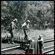 Workers laying continuous welded rail near Rennie, Ontario