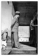 Unidentified man in suit standing on porch