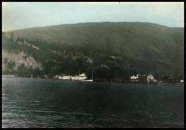 Hand coloured photograph of Slocan from West Slocan with S.S. Slocan at wharf