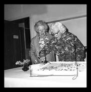 Mrs. Beairsto and Mrs. Kinnard cutting cake during a celebration