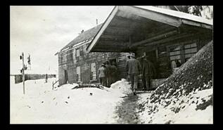 Group of men at the doorways of Nickel Plate Mine buildings