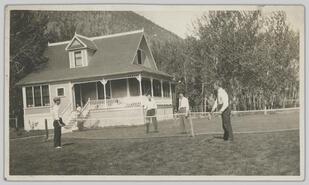 Men playing tennis on lawn