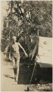 Boy Scout Jack Greysin in bathing suit outside of tent at Chute Creek
