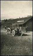 Jim McKay in automobile in front of Columbia River Lumber Co. warehouse