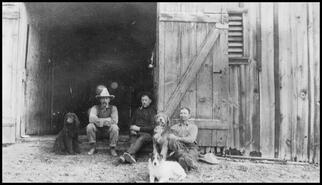 Three men at barn with dogs
