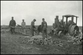 [Group of men running a portable sawmill for firewood]