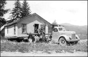 Baird Bros. truck moving a house