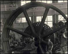 Tom Hinton with flywheel, old rope driven compressor, zinc plant compressor room