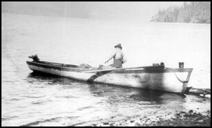 Man in river boat on Mabel Lake