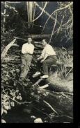 G.L. McNichol and Charles Flood sitting on a log