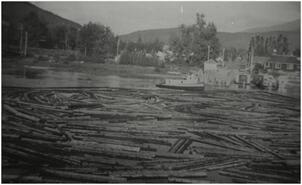 Tugboat "MPF" with log boom in Sicamous Channel at foot of Finlayson St.