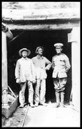 Two miners in the Monashee mine entrance with a soldier