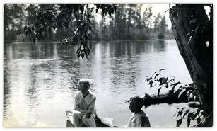 Helen and Ken Campbell sitting on the shore of the Kettle River