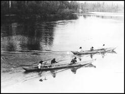 Shuswap Indigenous women racing down the Shuswap River near Enderby in hand carved dugout canoes
