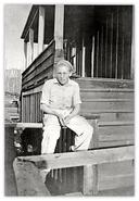 Young man sitting on stair railing of house in Anyox