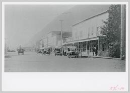 View of Main Street with cars and a horse pulling a carts