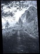[Dirt road beside Skaha Lake with views of bluffs]