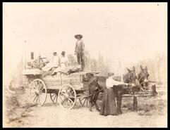 Family moving using wagon pulled by two mules