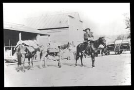 Bill Armstrong on horseback with pack horses
