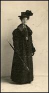 Grace Duncan posing in coat and hat with umbrella