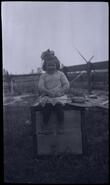 Child seated on a box