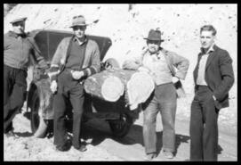 Ted Dawe, Stan Lockhard, George Langlands, and Bill Suckling with logs in a vehicle