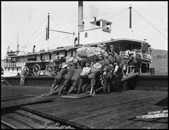Men loading a wagon of army supplies onto the S.S. Aberdeen sternwheeler docked at Okanagan Landing