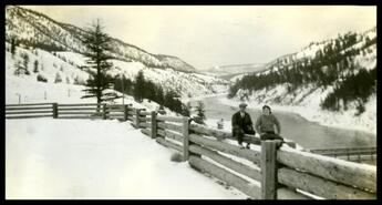 J.C. Johnstone and Girlie Johnstone sitting on fence with river valley