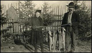 Sinclair Craig and unidentified girl holding pole with fish