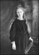 Letty Schofield as a young girl wearing a velvet dress with white lace collar and cuffs
